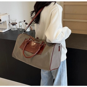 Detail of khaki canvas travel bag with leather handles and adjustable shoulder strap
