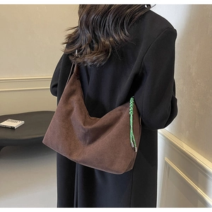 Detail of dark brown suede hobo bag with unique green braided zipper pull decoration