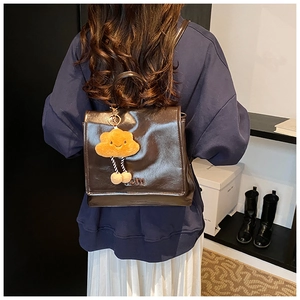 Detail of vintage brown gloss PU leather backpack with flip cover and cute cloud charm