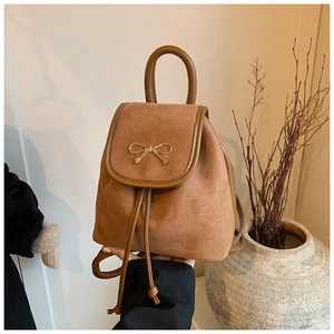 Nahaufnahme brauner Wildleder-Minirucksack mit Vintage-Metallschleife und Textur