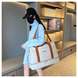 Détail du sac de voyage montrant le compartiment à chaussures et la séparation humide-sec