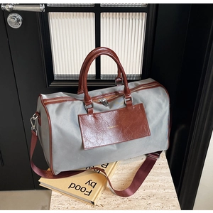 Macro shot of grey fabric texture and brown leather accents on a large travel tote bag