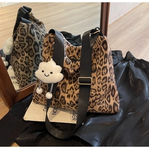 Detailansicht der Leopard-Tasche mit schwarzem Canvas-Gurt und Wolken-Anhänger-Charm