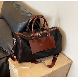 Detail of reinforced handles and bicolor stitching on a large capacity travel bag