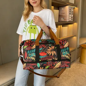 Detail of leaf print travel bag featuring a bottom shoe compartment and shoulder strap