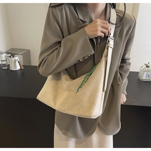 Détail du sac demi-lune en daim beige avec corde tressée verte et bandoulière réglable