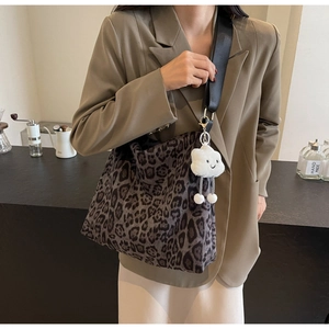 Detail der Leopard-Tasche mit schwarzem Schultergurt und weißem Wolkenanhänger