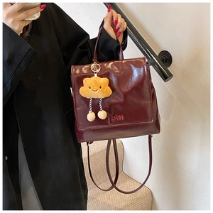 Detail of burgundy patent leather backpack with fbm embossing and cloud charm
