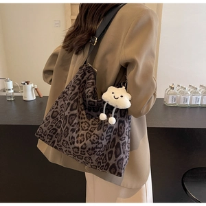 Detaillierte Nahaufnahme der Leopard-Tasche mit einem weißen Plüsch-Wolken-Anhänger