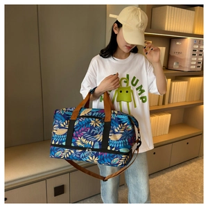 Détail du sac de voyage bleu à motif érable avec compartiment chaussures et poignées