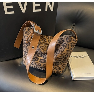 Detail of leopard print tote bag with wide camel leather strap and silver metal buckle