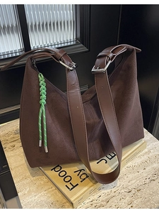 Retro dark brown suede bucket tote bag with wide leather straps and green woven charm