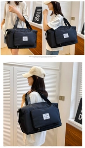 Primer plano de la bolsa de viaje de tela oxford negra con asas reforzadas y parche