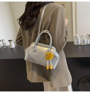 Borsa a mano argento metallizzato con chiusura a scatto e ciondolo mostro di peluche