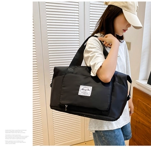 Detalle de la bolsa de viaje de nailon negro con cremallera de expansión en la base