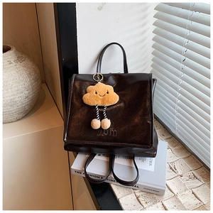 Close-up of vintage dark brown glossy leather backpack with a cute cloud charm detail