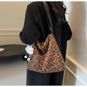 Detailansicht der großen Leopard-Tote-Bag mit Plüschanhänger an der Schulter des Models