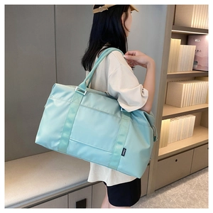 Close-up of mint green waterproof travel bag with Hong brand label on a shoulder strap