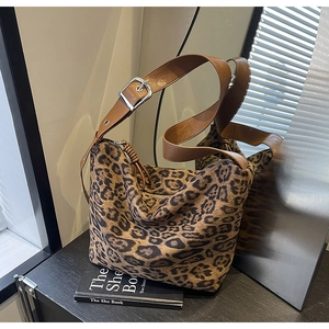 Detail of leopard print tote bag with brown shoulder strap and silver metal buckle