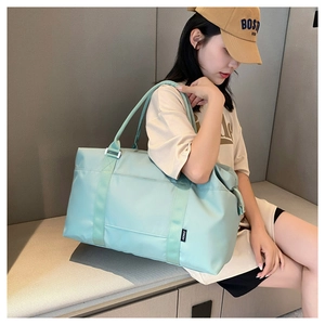 Close-up of waterproof mint green travel bag with wide reinforced handles for gym and travel