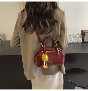 Modella che indossa la borsa a tracolla vintage bordeaux scuro con ciondolo peloso