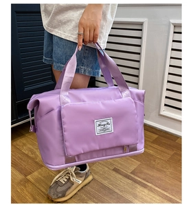 Detalle de bolsa de viaje lila con compartimento inferior para zapatos y etiqueta