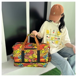 Détail du sac de voyage à motif tropical avec compartiment à chaussures et bandoulière