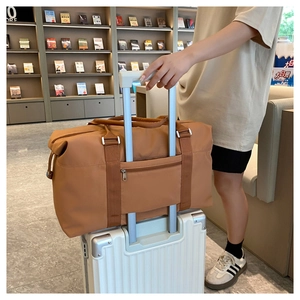 Brown travel bag with luggage sleeve attachment for easy mounting on suitcase handles