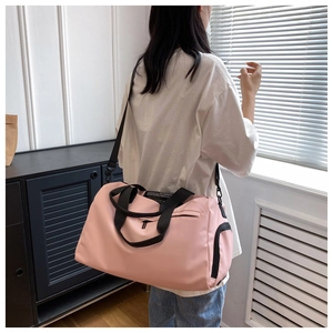 Detalle de bolsa de deporte rosa con separación húmedo-seco y correas negras resistentes