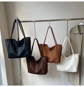 Detailed display of vintage leather tote bags in four colors hanging on a rack