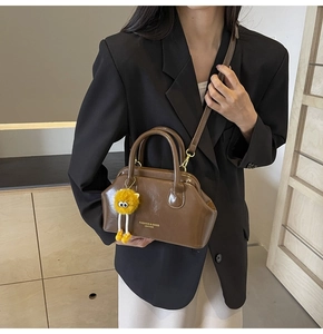 Borsa da medico vintage marrone con hardware dorato e ciondolo peluche mostro giallo