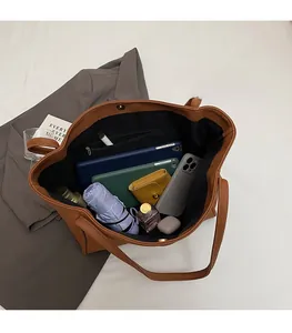 Top view of spacious brown tote bag interior with multiple items and zipper pocket
