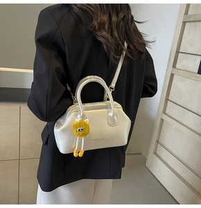 Moderna borsa a tracolla perlata con ciondolo peluche giallo su modella donna