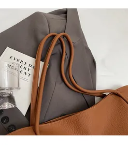 Detail of soft brown leather tote bag straps and texture with commuter styling