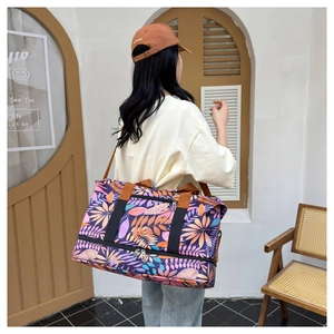 Détail du sac de voyage avec motif de feuilles d'érable et anses en nylon