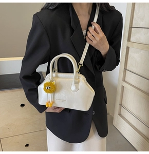 Borsa da medico color crema con ciondolo a mostro di peluche indossata da modella