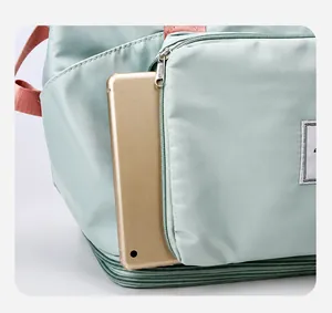 Detailed view of the front zipper pocket on a green travel bag holding a tablet device