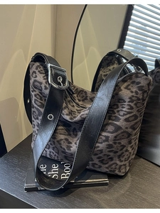 Large grey leopard print tote bag with wide leather strap shown on a dark surface