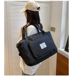 Close-up of black waterproof travel bag with bottom expansion layer and logo detail