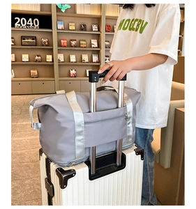 Bolso de viaje gris con banda para maleta acoplada al asa para un transporte muy fácil