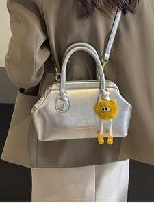 Borsa a tracolla argento metallizzato con ciondolo a mostro in peluche giallo