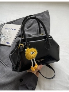 Borsa a mano retrò in pelle nera con doppi manici e ciondolo in peluche giallo