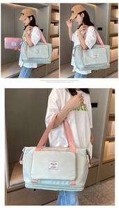 Detail of travel duffle bag with reinforced handles and front zipper pocket in mint and pink
