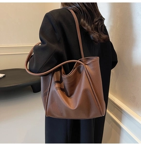 Close-up of caramel brown tote bag with premium lychee grain texture and double handles