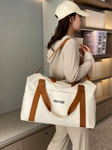 Large beige fitness yoga bag with brown straps shown on shoulder in a lifestyle setting