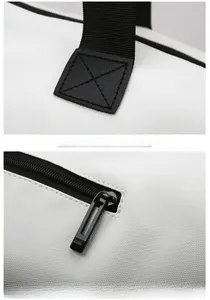 Detail of reinforced stitching on webbed handles and black metal zipper for gym bag