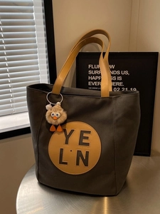 Minimalist large canvas tote bag in charcoal grey with mustard yellow leather handles and duck charm