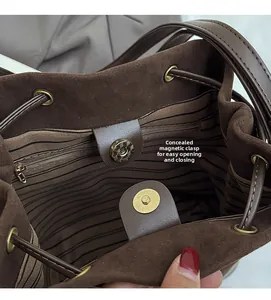 Macro shot of brown suede bucket bag interior with striped lining and magnetic snap