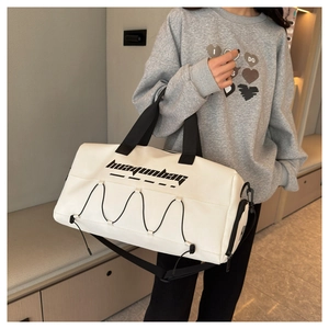 White waterproof sports bag with black handles and shoulder strap in a gym scenario