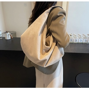Detailed view of beige suede tote bag styled with a brown blazer for a commute outfit